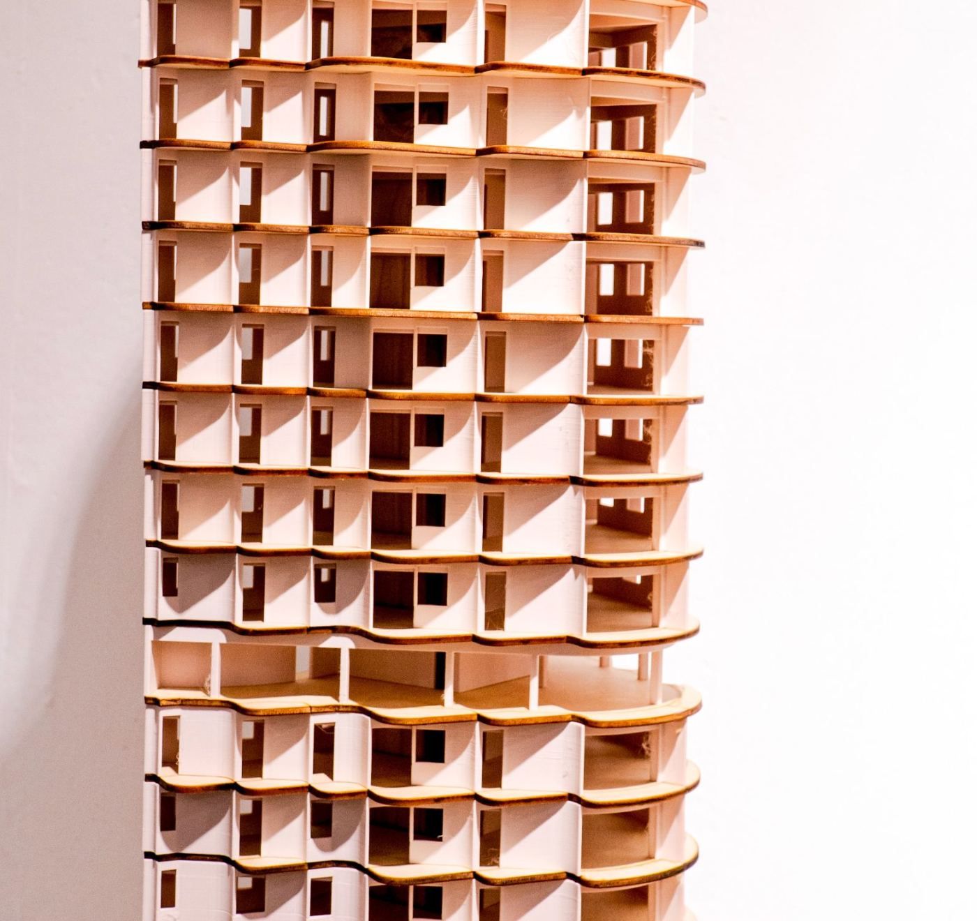 A tall physical model of the tower, its floors ringed by curved balconies of different depths
