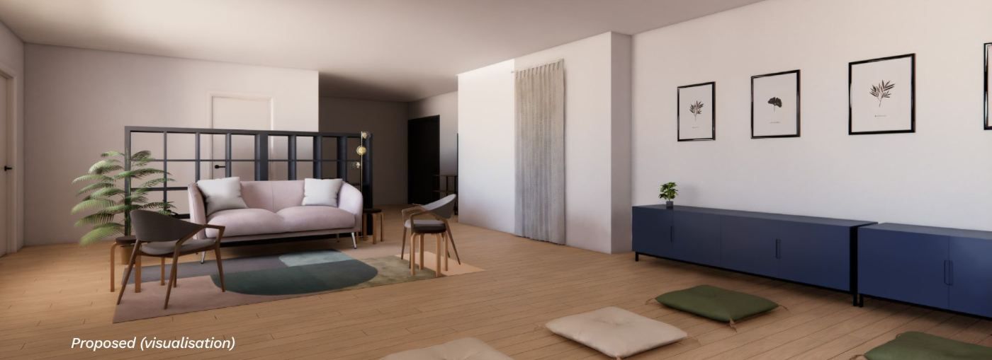 Visualisation of the centre's gathering space with a sofa, low tables, framed pictures and a bookshelf divider